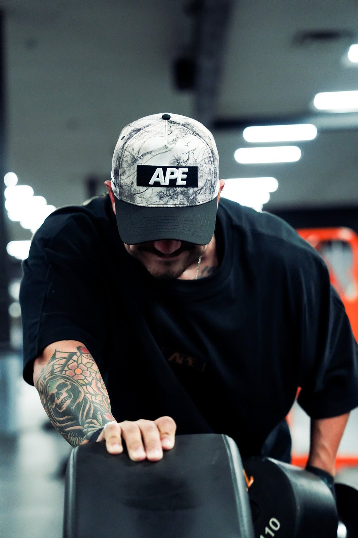 Athlete wearing the camo APE hat in the gym